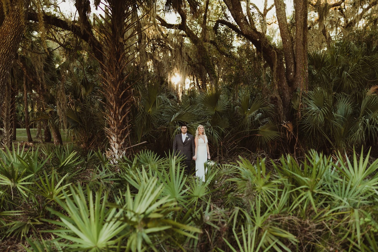 badass bride and groom portrait surrounded by palms at Tampa Palms Country Club in Tampa, Florida.