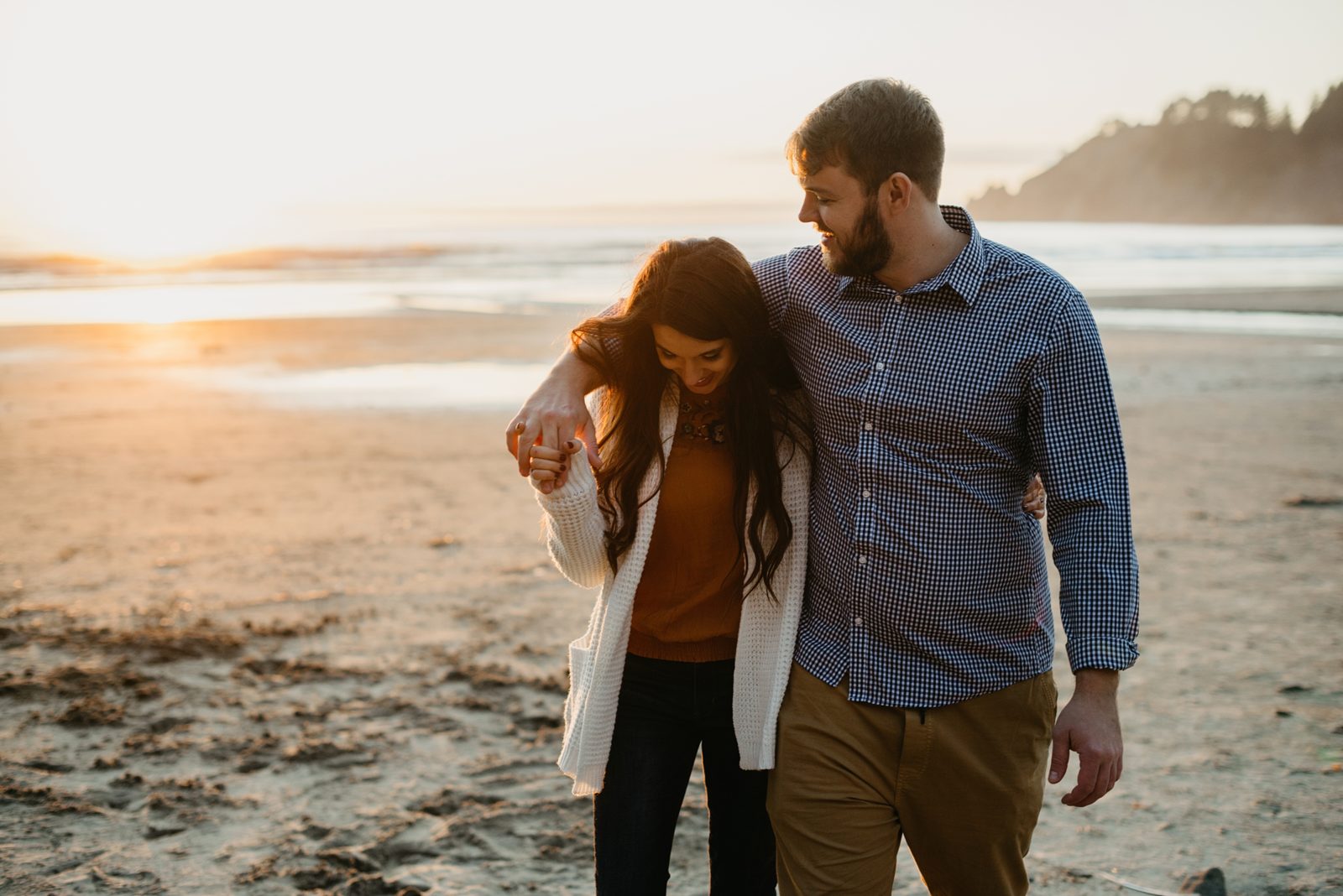 Couple walking on beach at sunset during the engagement photos on the Oregon Coast