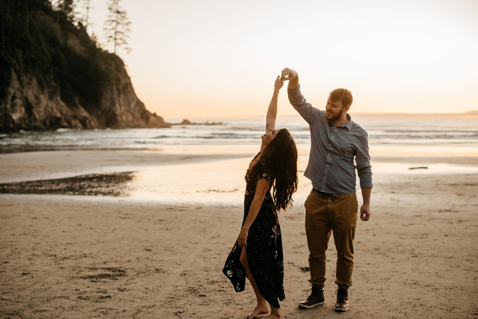 Couple dancing on the beach at sunset during engagement shoot at the Oregon Coast