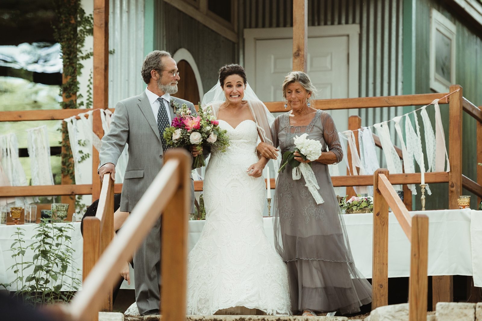 Excited bohemian bride walking down aisle with mother and father at The Sanctuary Austin