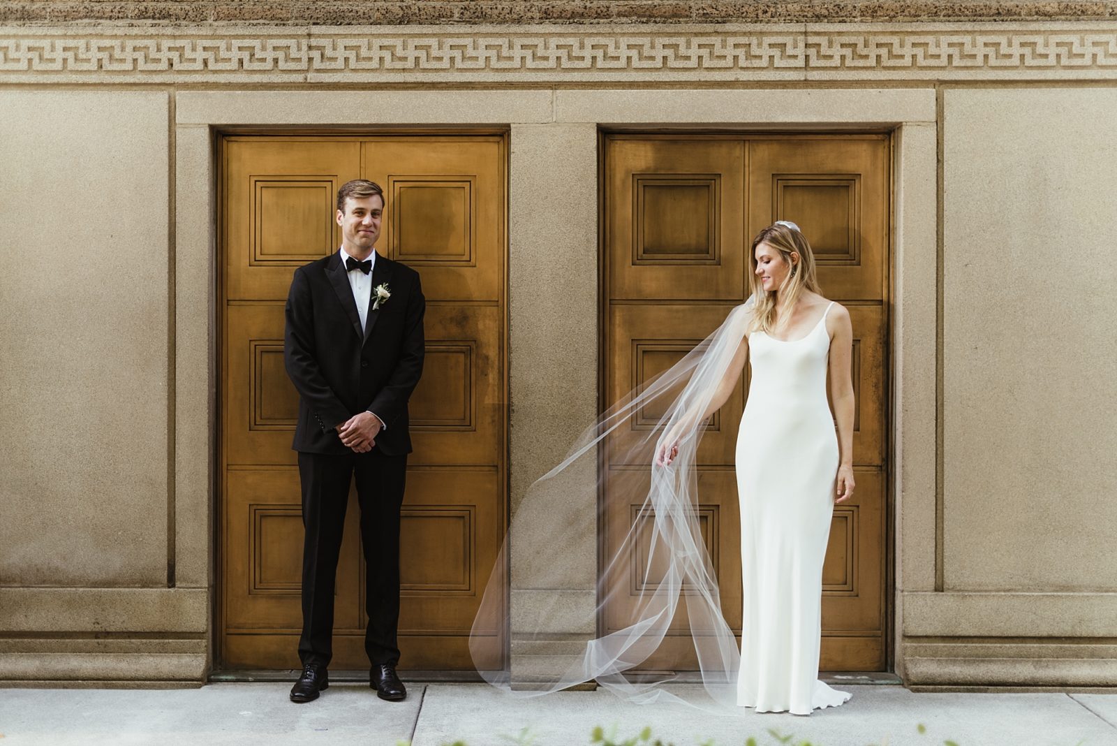 Modern and stylish couple in front of gold doors in downtown Portland during bride and groom portraits