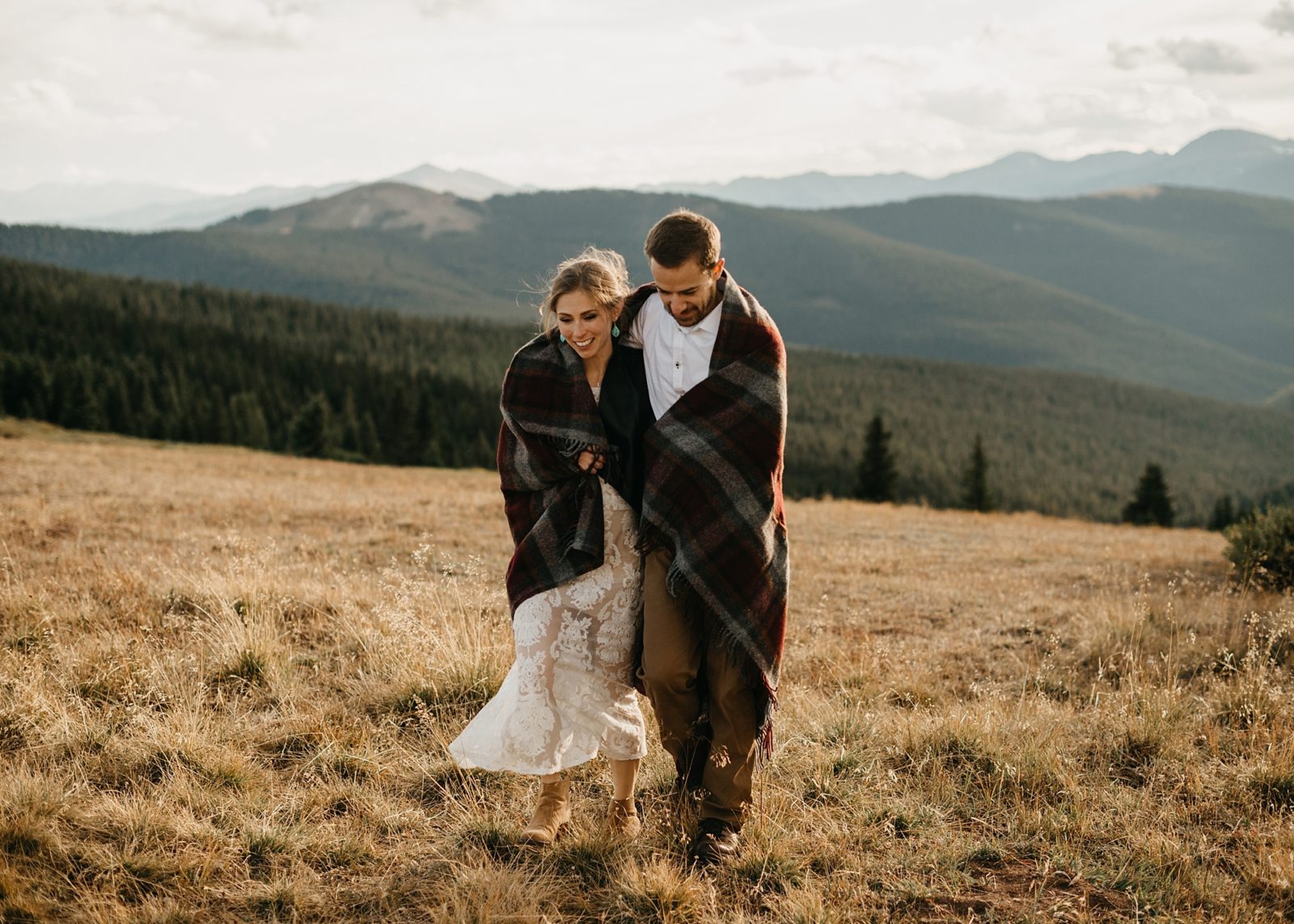 Couple wrapped in blanket on a mountain top in Vail, Colorado
