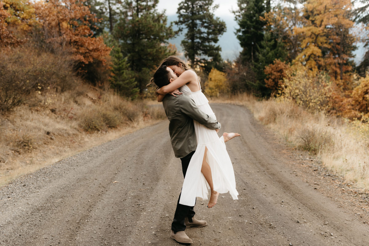 couple spinning around during autumn engagement shoot
